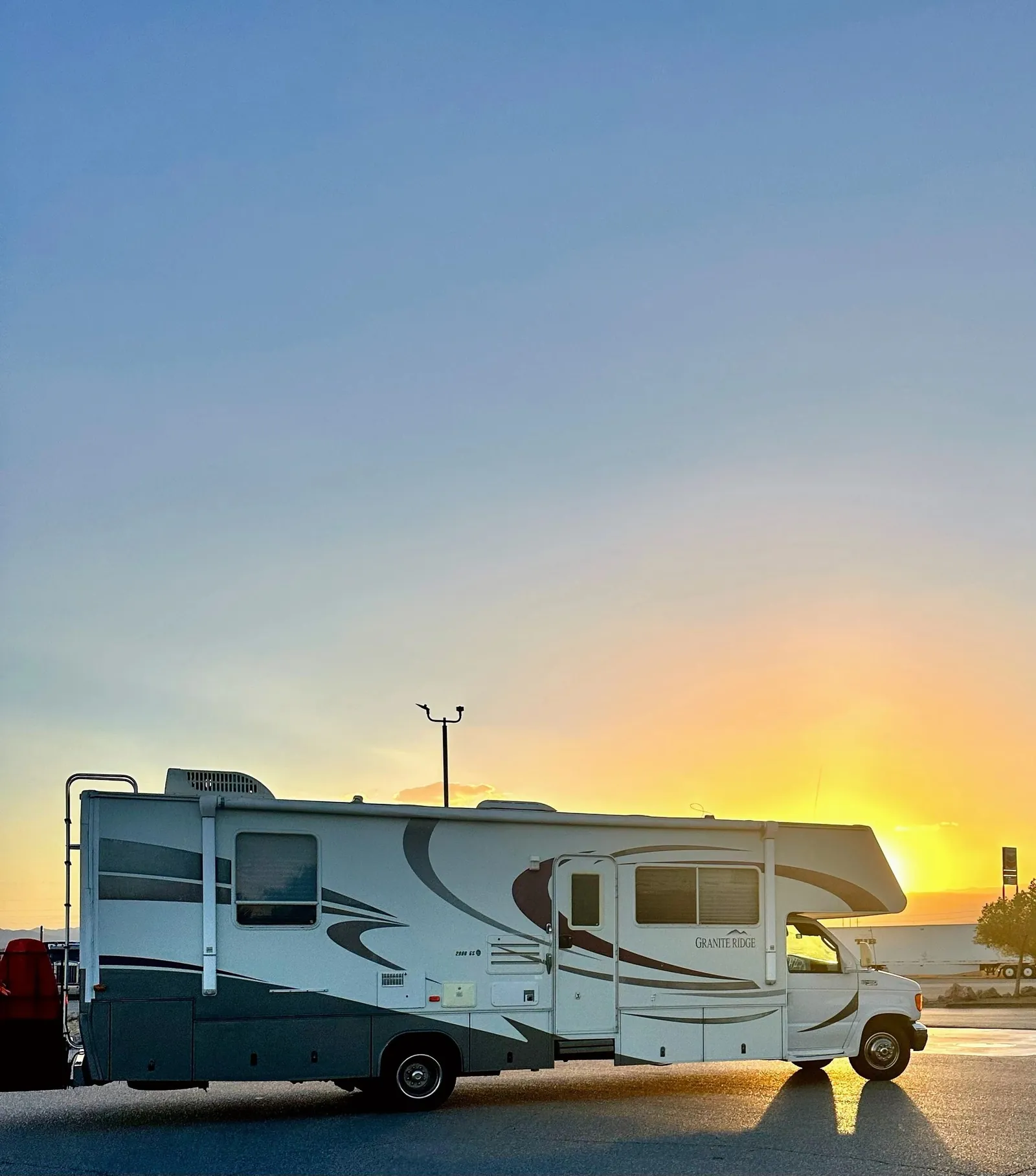 The Green Machine RV parked beneath a colorful sunset